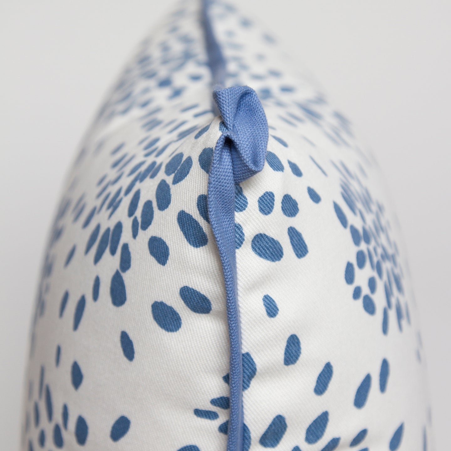 Close-up of the butterfly corner flange detail on the light blue “Fireworks” pillow by Albert Hadley, showing the contrasting twill.