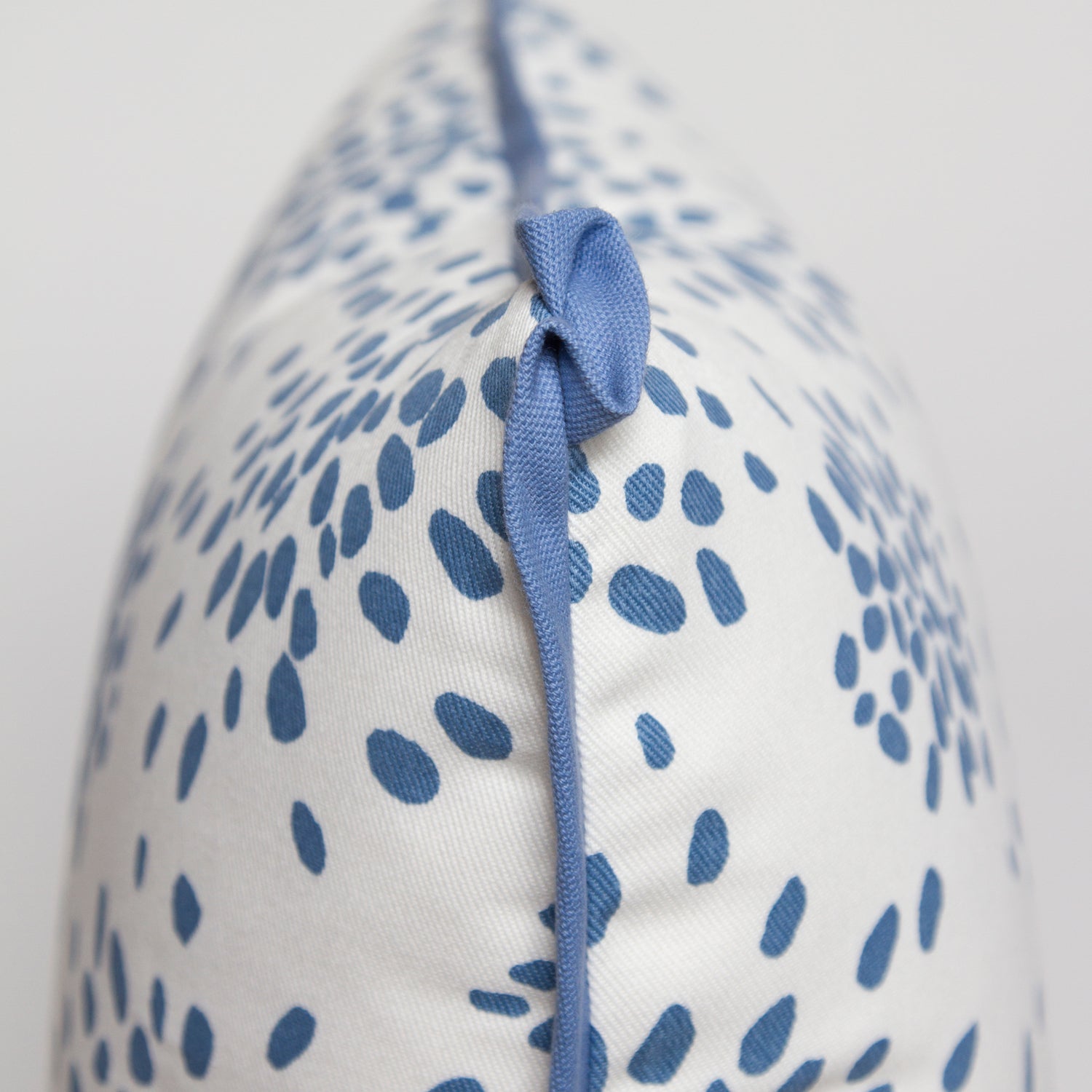 Close-up of the butterfly corner flange detail on the light blue “Fireworks” pillow by Albert Hadley, showing the contrasting twill.