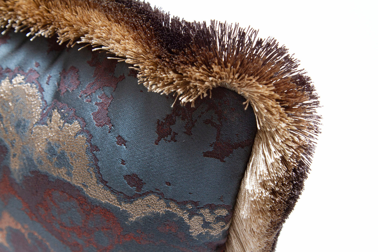 Ombre brush fringe detail on Woven fabric pillow with cerulean, silver, copper, and burgundy hues.