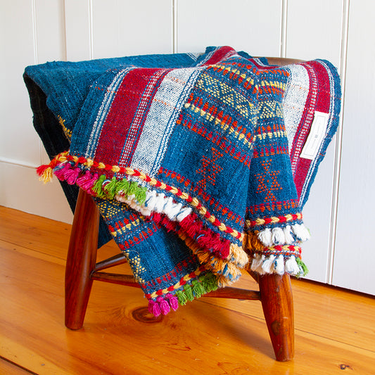 Handwoven wool blanket with multi-colored tassels, 36” x 88”, made from 100% wool, featuring vibrant hand-dyed colors.