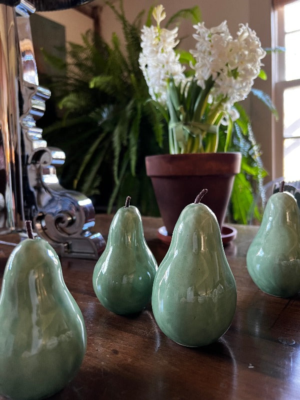 Handcrafted ceramic pears with a celadon glaze, varying in size from 3 to 5 inches tall.