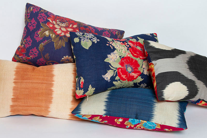 Nina Wildflower Blue ikat pillow with handwoven silk/cotton front and vintage Russian printed cotton back, 10x16 size with other pillows.