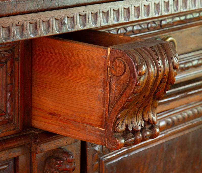 Secret compartment detail on 17th-century Florentine credenza in walnut with intricate carvings, original bronze hardware.