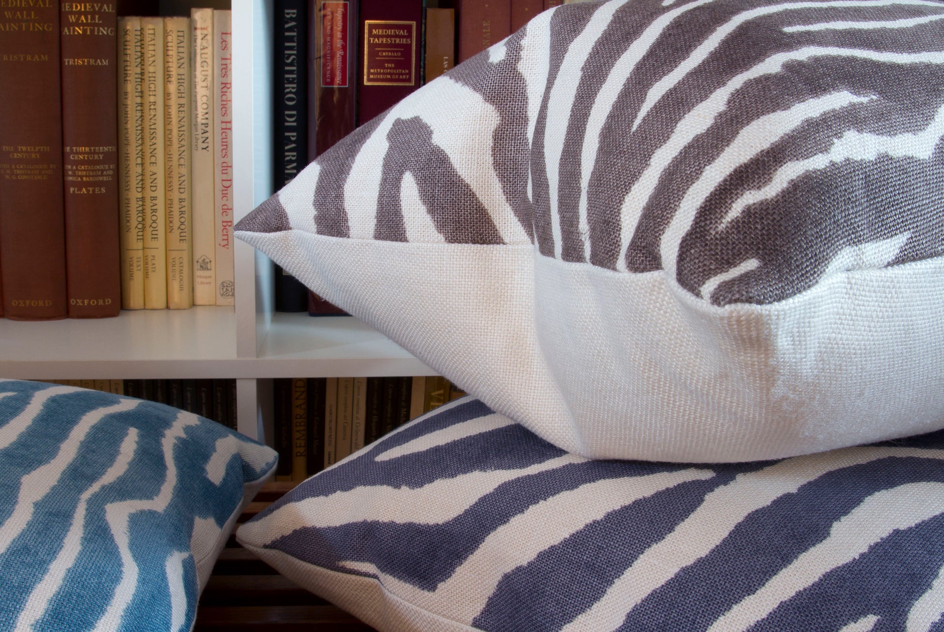 Close-up of teal, brown, and gray zebra print pillows in geometric design on 100% linen, showcasing the intricate pattern and texture.