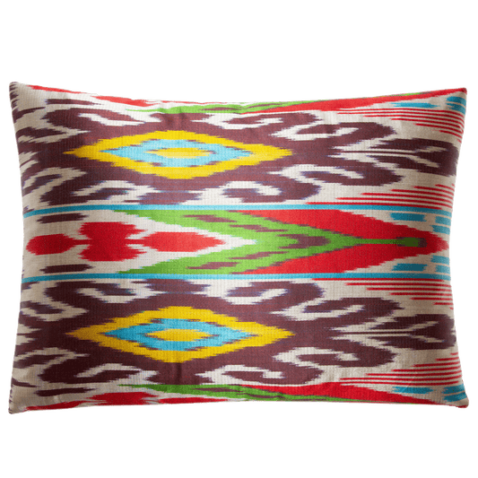 Multicolored silk ikat pillow in magenta, saffron, aubergine, and green on ecru. Size: 13” x 18”.