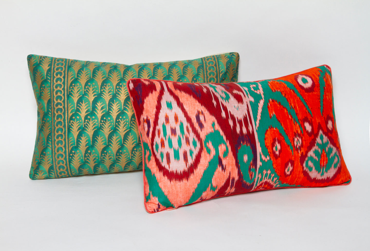 Pierre Frey pillow in bold ikat design featuring tangerine, coral, and teal, available in 10” x 16” or 14” x 24”.