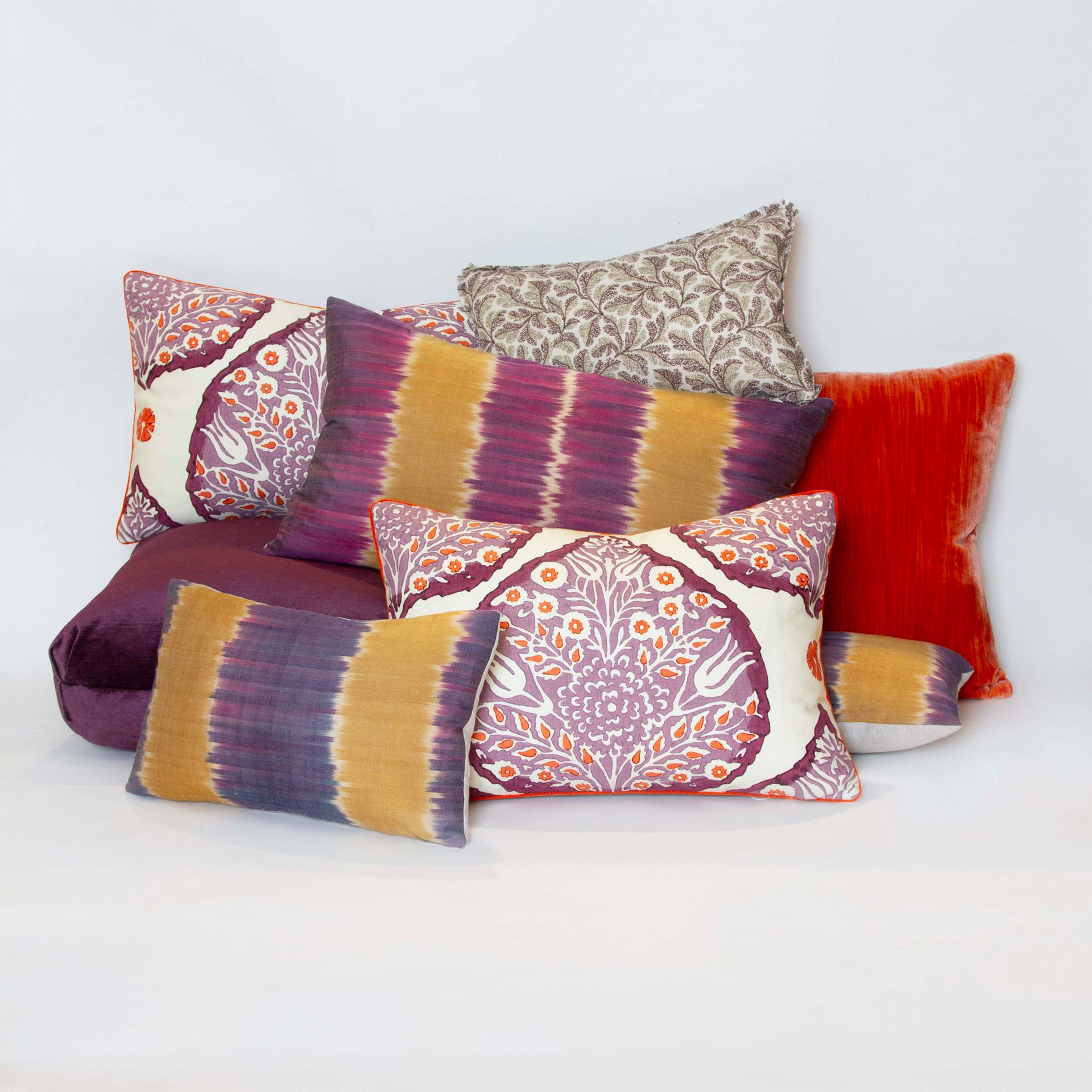 Galbraith and Paul pillow, 14” x 20”, with plum and paprika lotus print on creme linen, purple linen back, and paprika cord with other pillows.