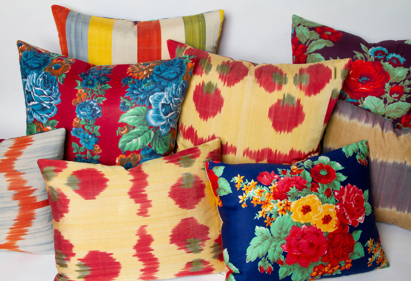 Reversible Miel Blue Rose and Red ikat pillow, handwoven fabric from Uzbekistan, with vintage Russian printed fabric back with other pillows.