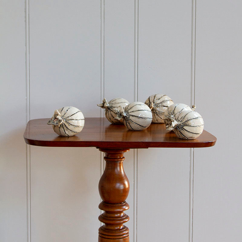 Hand-sculpted ceramic onions in eggshell and gray glaze, measuring 4 to 6 inches in size.