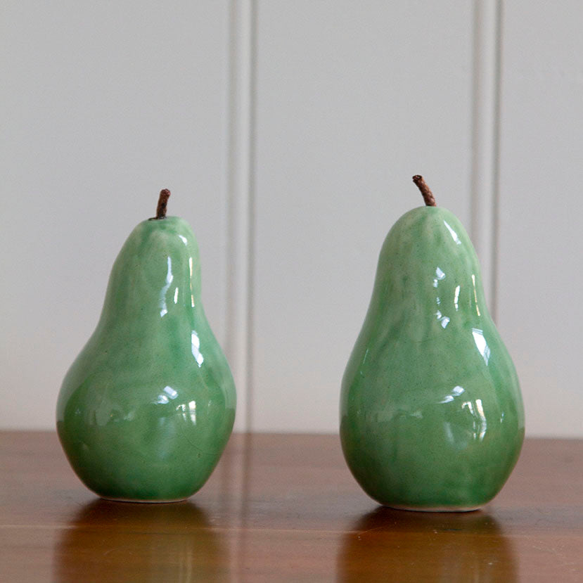 Detail of glaze on handcrafted ceramic pears with a celadon glaze, varying in size from 3 to 5 inches tall.