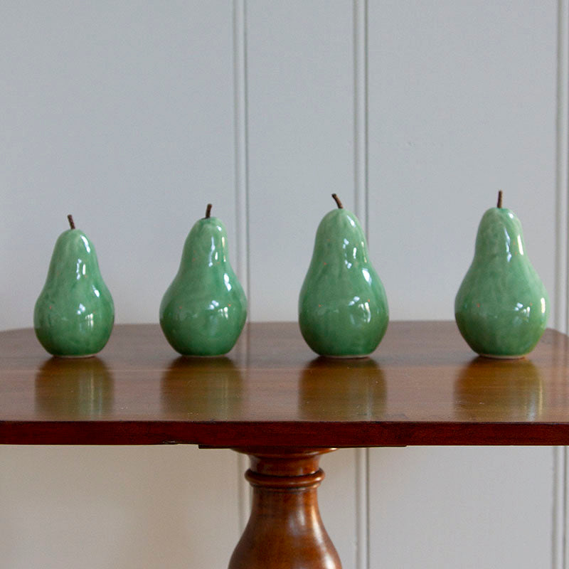 Handcrafted ceramic pears with a celadon glaze, varying in size from 3 to 5 inches tall.