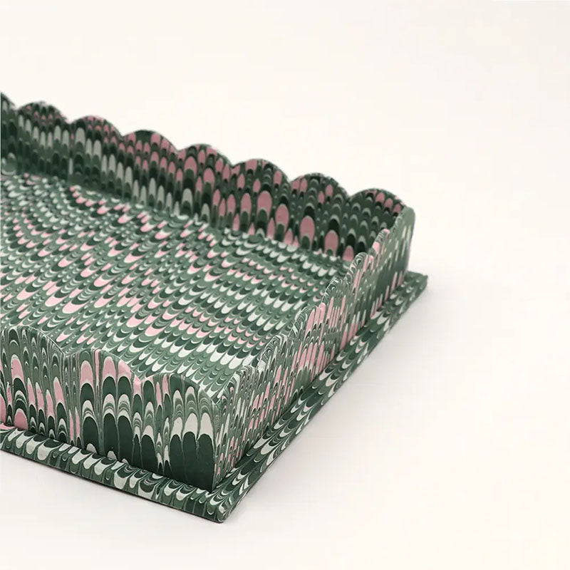 Corner detail of handmade marbled scalloped trays in green, 100% cotton, measuring 12” x 9.5” x 2”. 