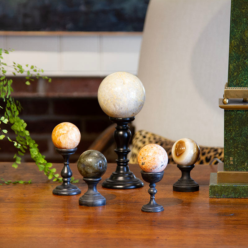 Antique carved stone sphere on a Florentine wooden pedestal with ebonized finish. Small: 4.6” to 6.15” H, Large: 10” H.