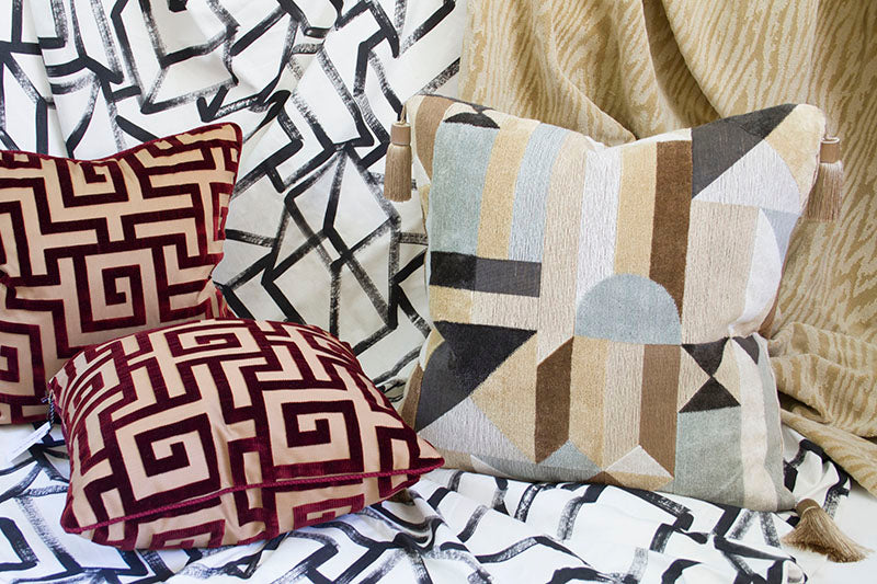 Clarence House Weimar linen velvet pillow with geometric art deco design in neutral tones with other pillows.