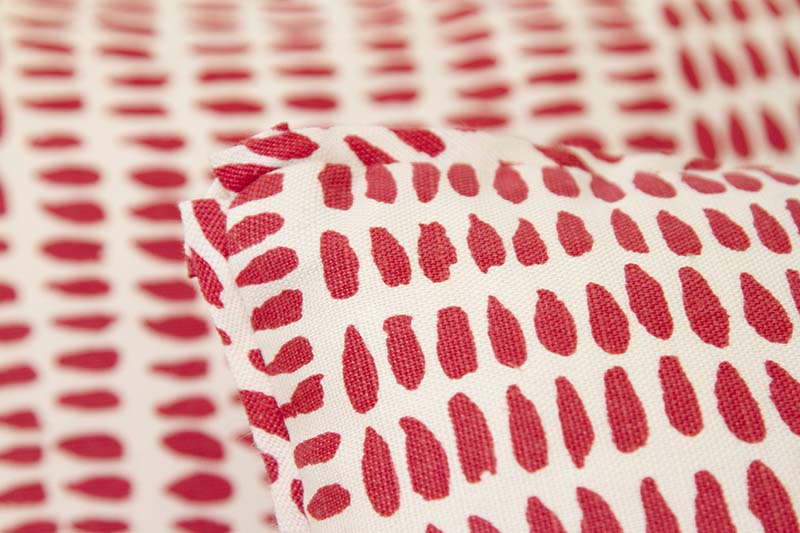 Fabric and flange trim detail on 22” x 22” pillow featuring pink tiled dashes on linen/cotton fabric.